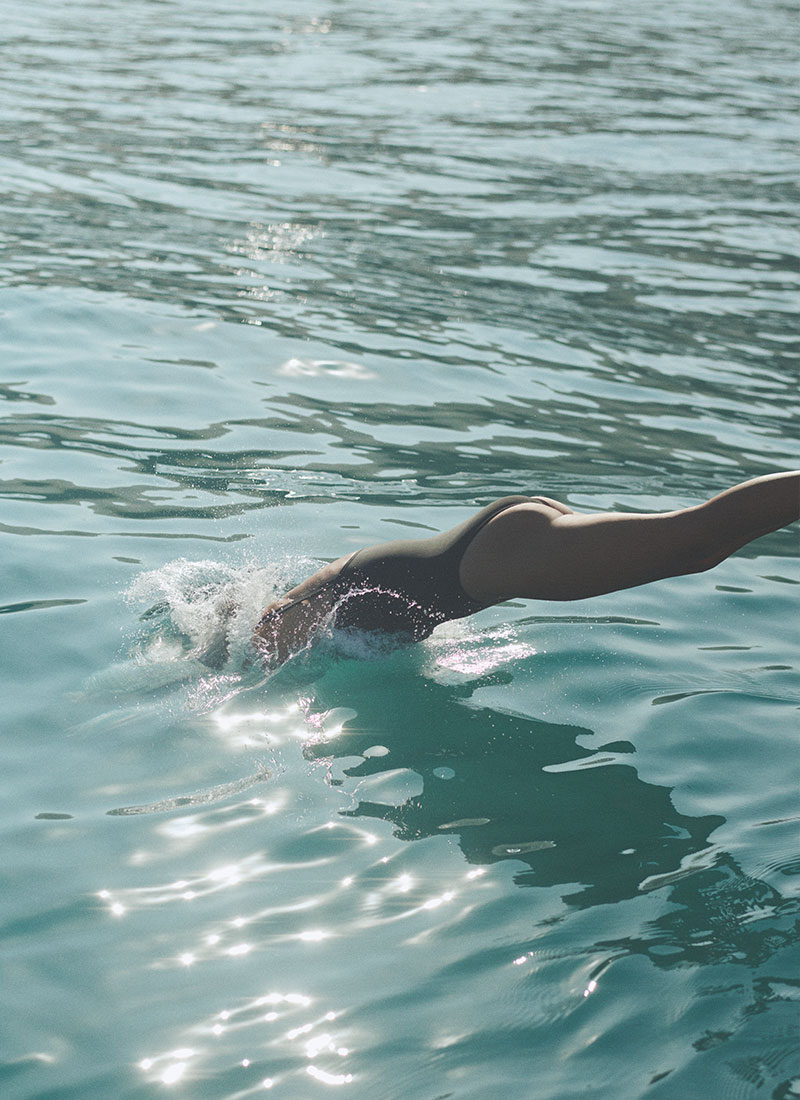 Woman diving into the crystal-clear waters of the Indian Ocean at NIHI Sumba, embracing freedom and wellness in a luxury tropical setting.