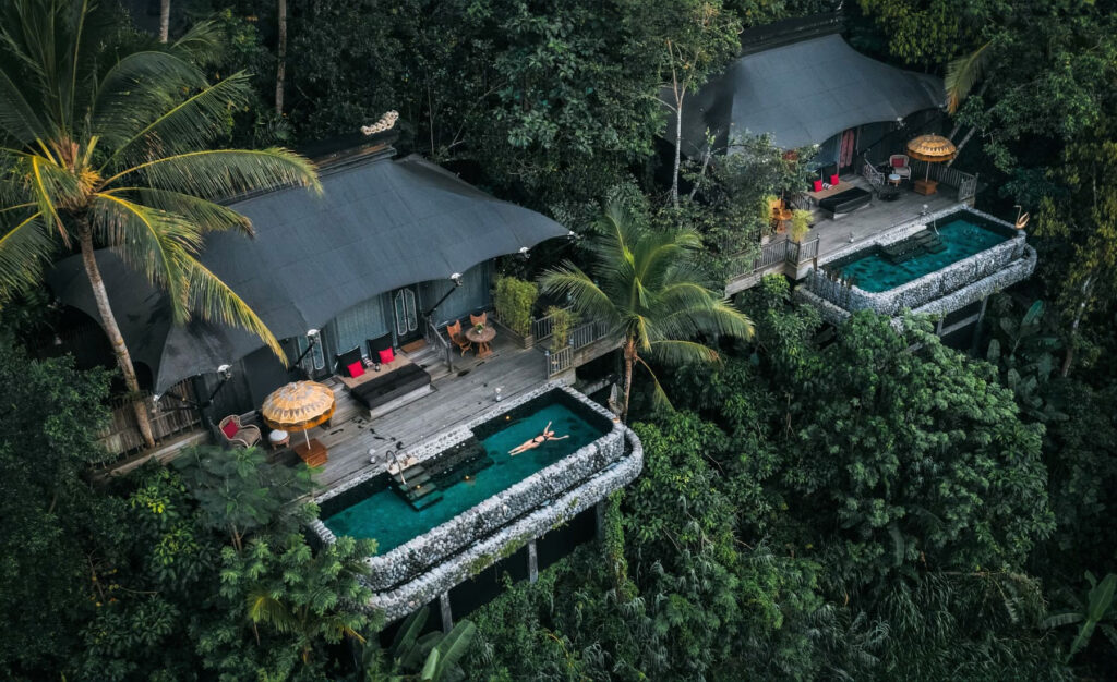 Aerial view of a luxury tented retreat at Capella Ubud, Bali—one of NIHI’s partner properties—featuring a private saltwater pool surrounded by dense rainforest, offering an immersive jungle experience.