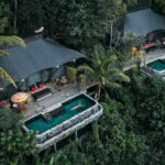 Aerial view of a luxury tented retreat at Capella Ubud, Bali—one of NIHI’s partner properties—featuring a private saltwater pool surrounded by dense rainforest, offering an immersive jungle experience.
