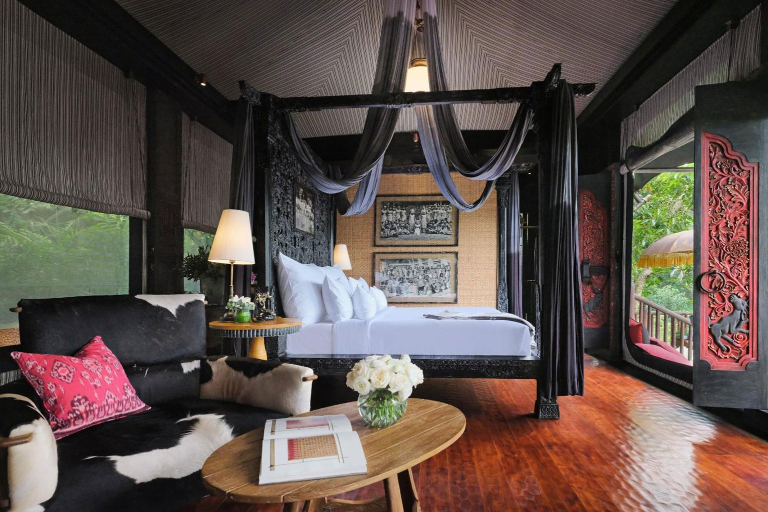 Interior of a Capella Ubud tent featuring a four-poster bed, draped canopies, and traditional Balinese decor, with views overlooking the lush tropical rainforest—part of the 'Awaken to Magic' journey with NIHI Sumba.