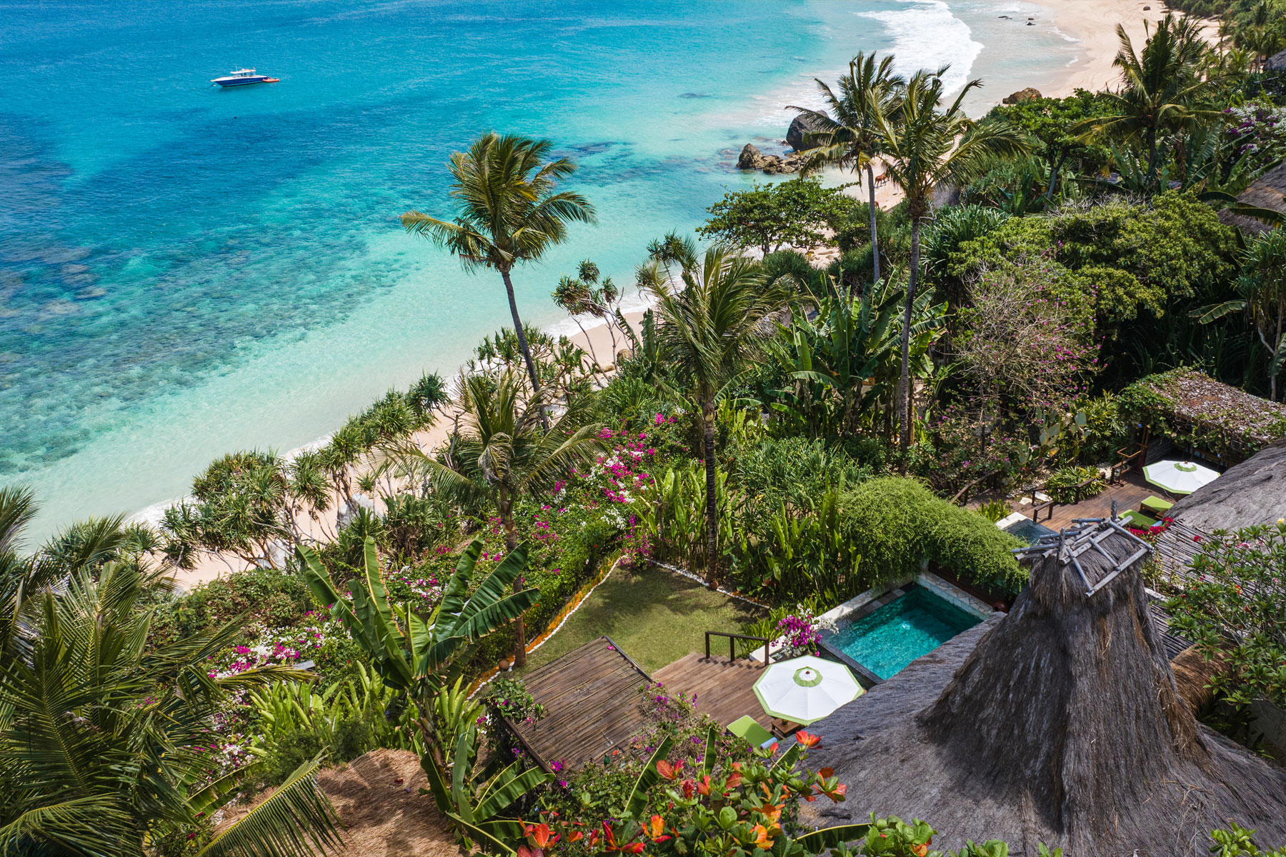 Aerial view of Marangga Occy’s Villa at NIHI Sumba, showcasing the villa’s private plunge pool, outdoor dining area, and lush tropical gardens leading directly to the secluded white-sand Nihiwatu Beach and turquoise sea.