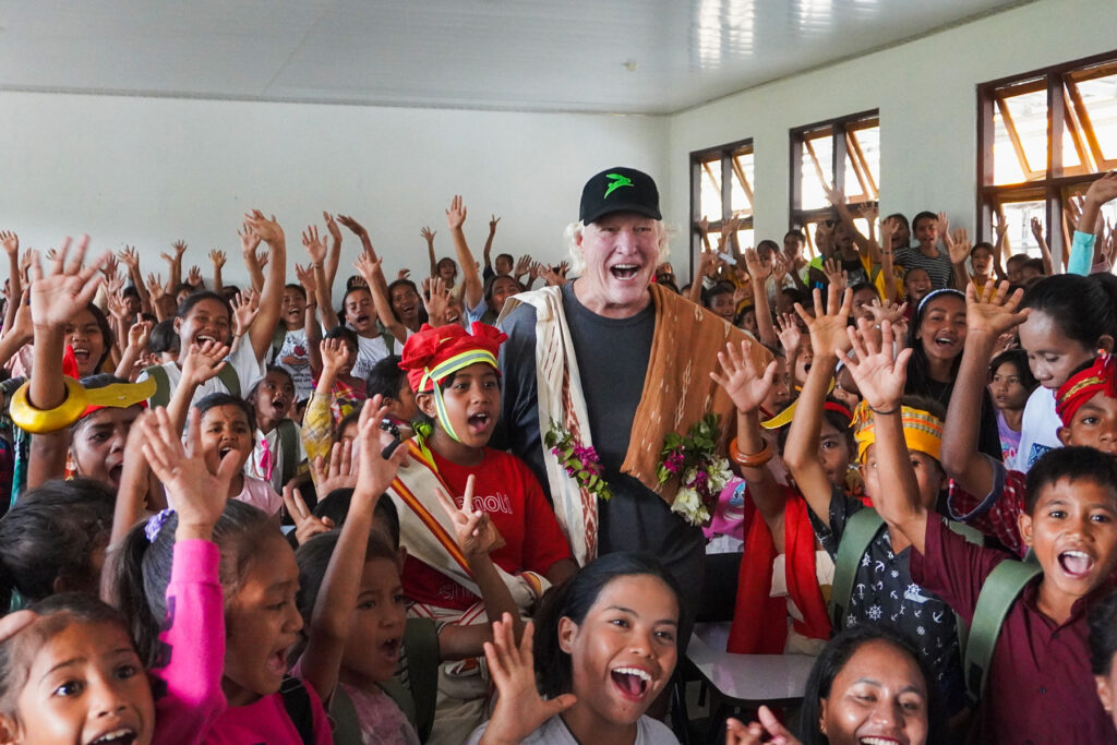 Chris Burch, during one of his regular visits to the community and Burch Family Foundation projects, is joyfully welcomed by a large group of enthusiastic Sumbanese students during an English class at the Learning Development Center, supported by NIHI Sumba.