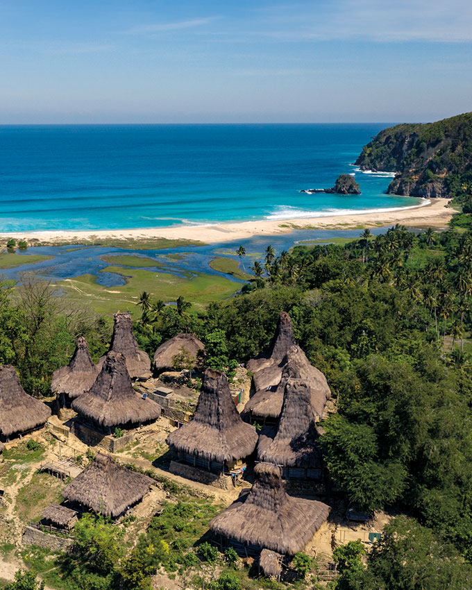 Aerial view of Yaro Wora Village, featuring traditional peaked thatched-roof houses near the coastline, overlooking the Indian Ocean.