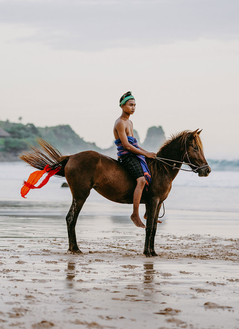 Young Sumbanese horse rider in traditional attire during Pasola demonstration at NIHI Sumba, Indonesia.
