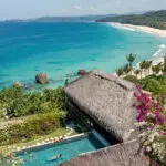 Aerial view of Raja Mandaka, Chris Burch’s private villa at NIHI Sumba, overlooking the turquoise waters of the Indian Ocean and the resort’s 2.5 km stretch of white sand beach, surrounded by lush tropical greenery