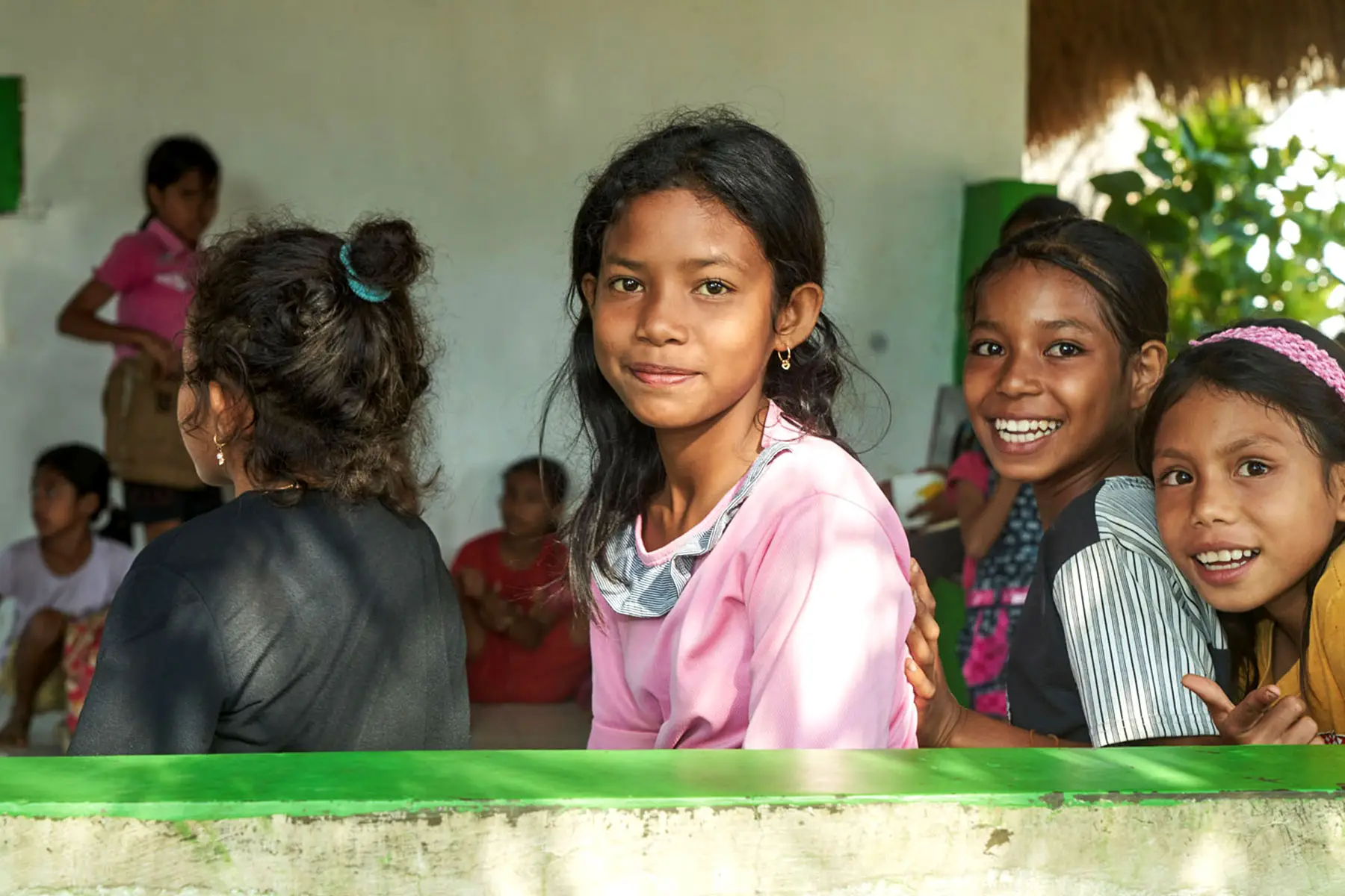 Young Sumbanese students smiling white attentively participating in an English class at the Sumba Foundation’s Learning Development Center, one of the cultural experiences organized by the resort for guests to interact with local children.