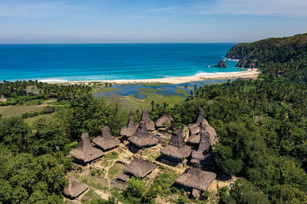 Aerial view of Yaro Wora Village, featuring traditional peaked thatched-roof houses near the coastline, overlooking the Indian Ocean.