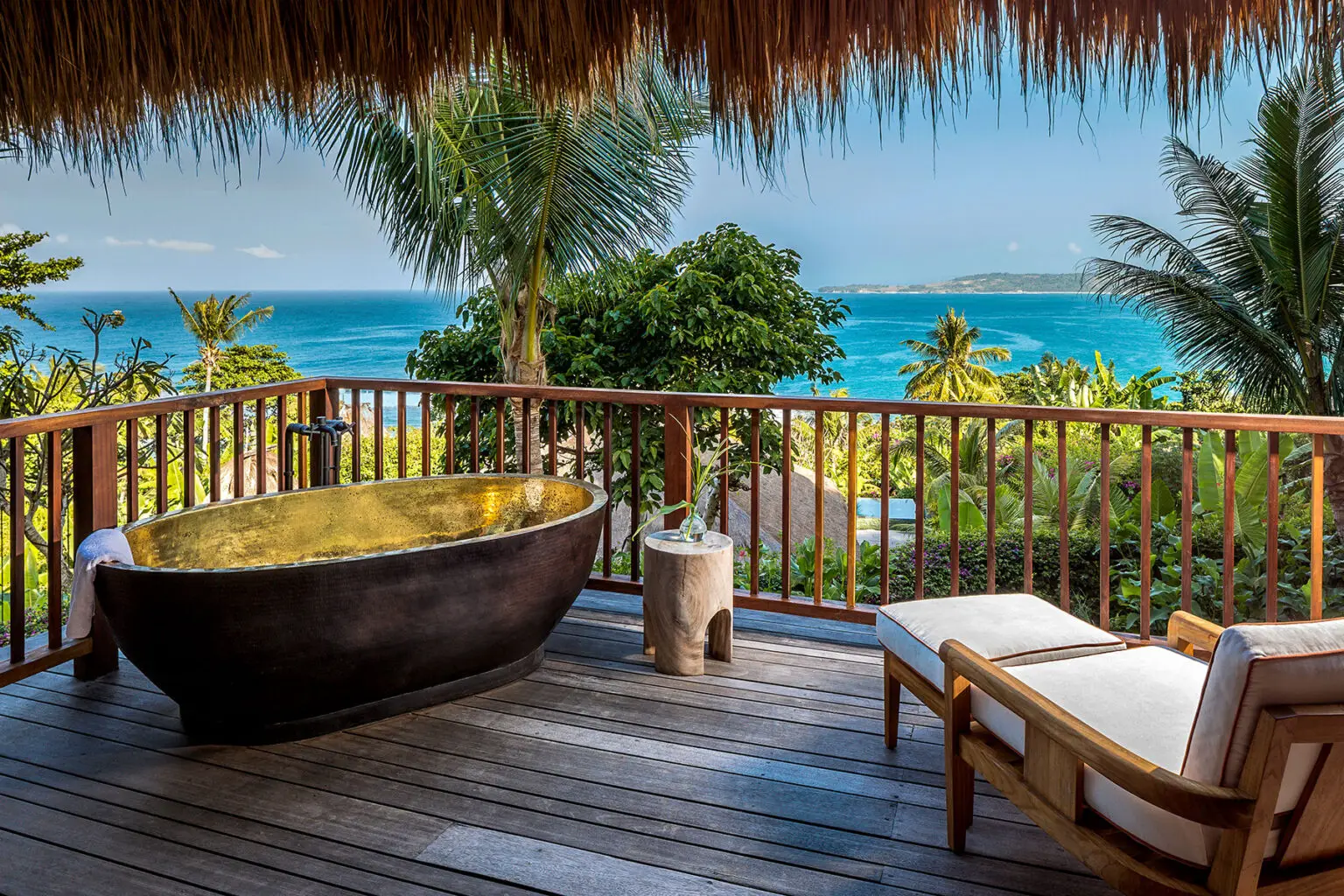 Outdoor bathtub at Puncak Sumba House, NIHI® Sumba, set on a wooden deck surrounded by tropical greenery, offering a serene and private open-air bathing experience.