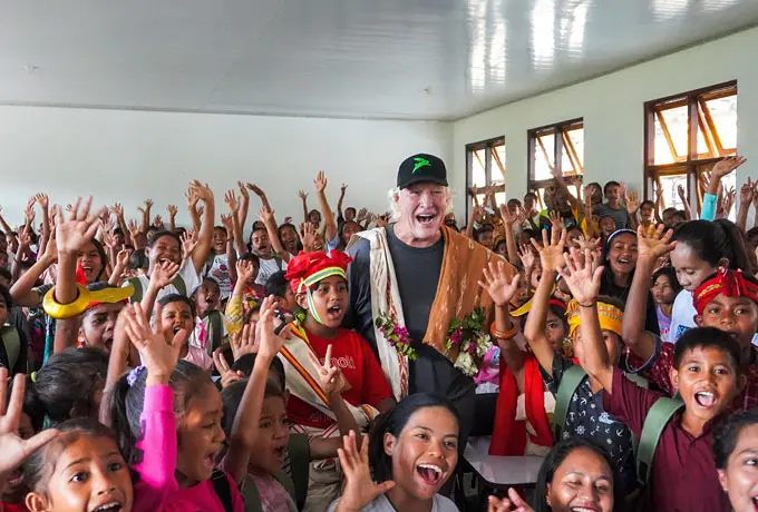 Chris Burch, during one of his regular visits to the community and Burch Family Foundation projects, is joyfully welcomed by a large group of enthusiastic Sumbanese students during an English class at the Learning Development Center, supported by NIHI Sumba.