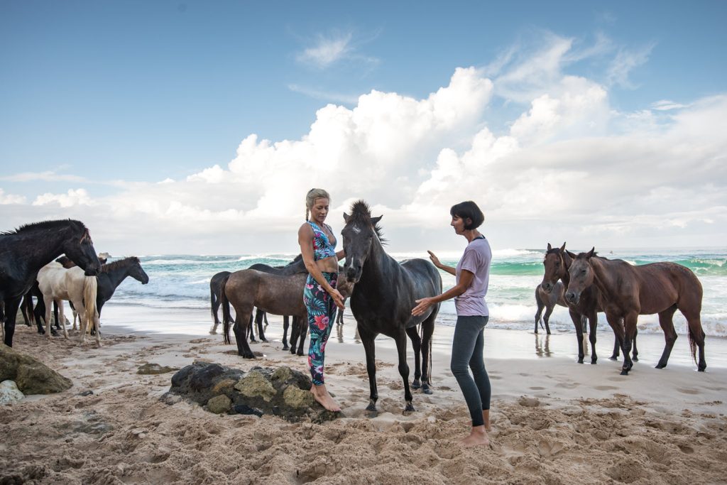 Yoga on the beach at hotel with horses on Sumba island, Indonesia.